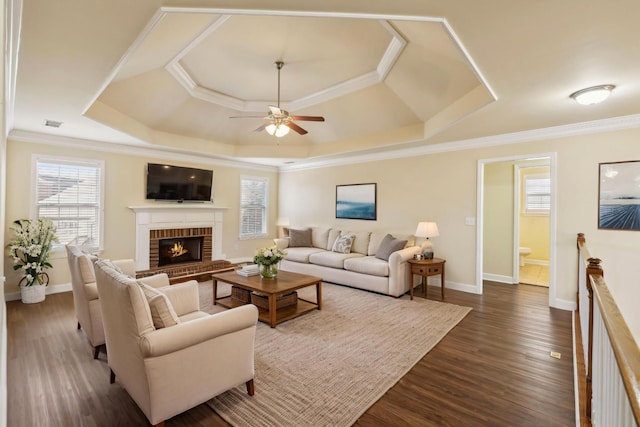 living area featuring a wealth of natural light, a tray ceiling, and a ceiling fan