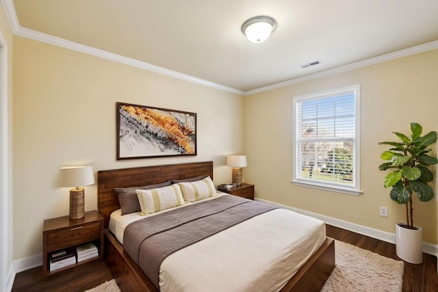 bedroom featuring dark wood-type flooring, baseboards, ornamental molding, and visible vents