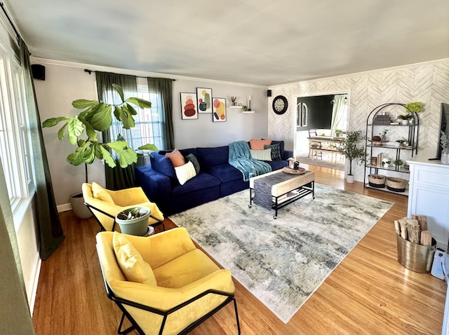 living area featuring crown molding, baseboards, and wood finished floors