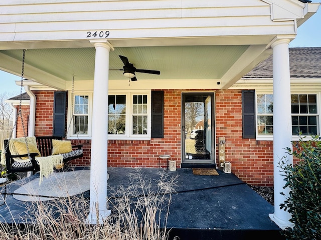 property entrance featuring a ceiling fan and brick siding