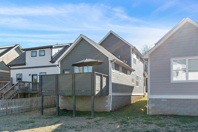 rear view of house with a yard, roof with shingles, fence, and a wooden deck