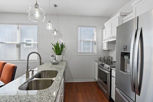 kitchen featuring dark wood finished floors, appliances with stainless steel finishes, under cabinet range hood, white cabinetry, and a sink