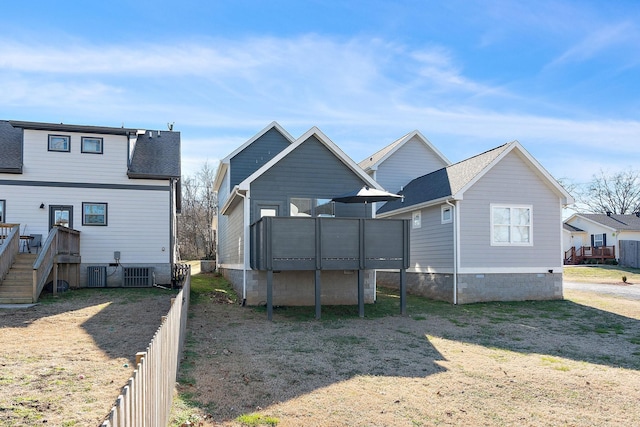 back of house featuring a shingled roof, a lawn, stairs, fence, and a wooden deck