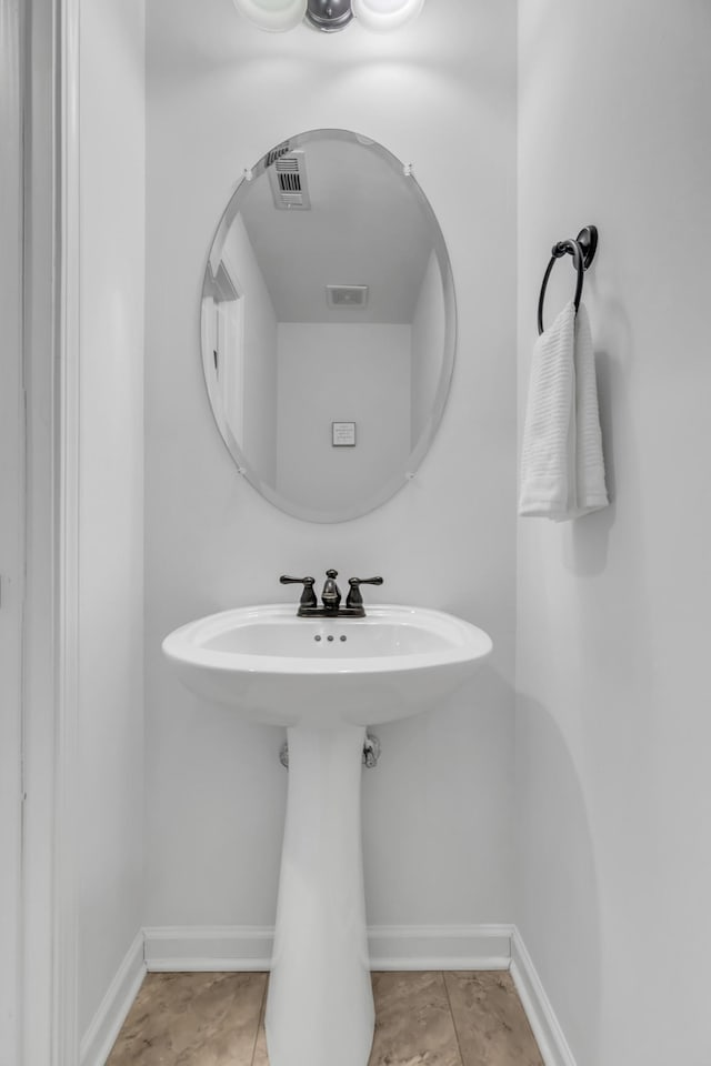 bathroom with a sink, visible vents, and baseboards