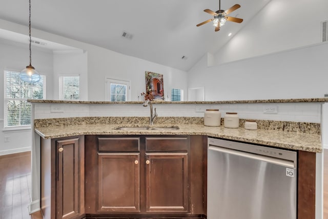 kitchen featuring light stone counters, a sink, vaulted ceiling, dishwasher, and tasteful backsplash