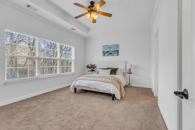 carpeted bedroom with baseboards, visible vents, a raised ceiling, and crown molding