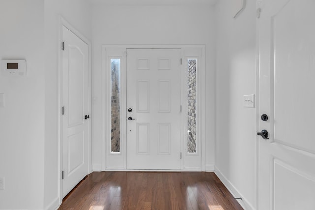 foyer entrance with plenty of natural light, dark wood finished floors, and baseboards