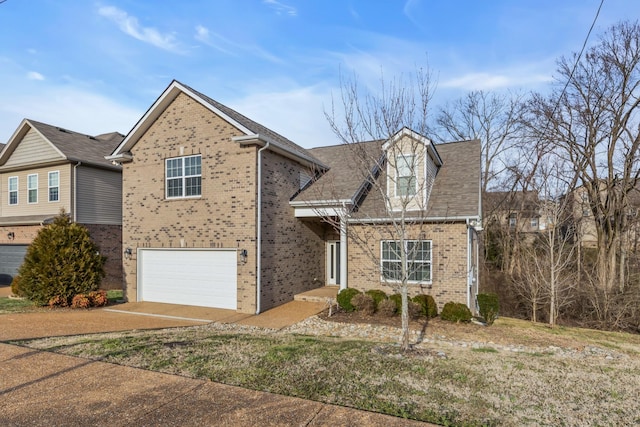 traditional-style home featuring a garage, driveway, and brick siding