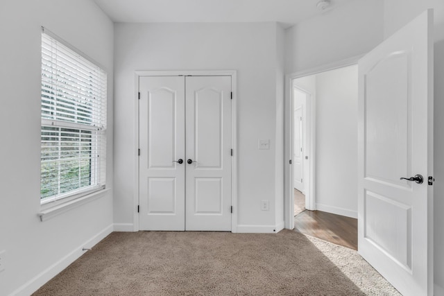 unfurnished bedroom featuring a closet, carpet, and baseboards