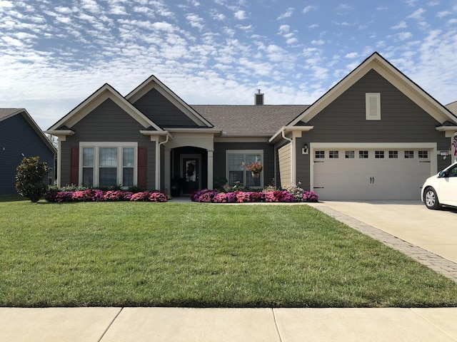 craftsman-style home featuring a garage, a front yard, and driveway