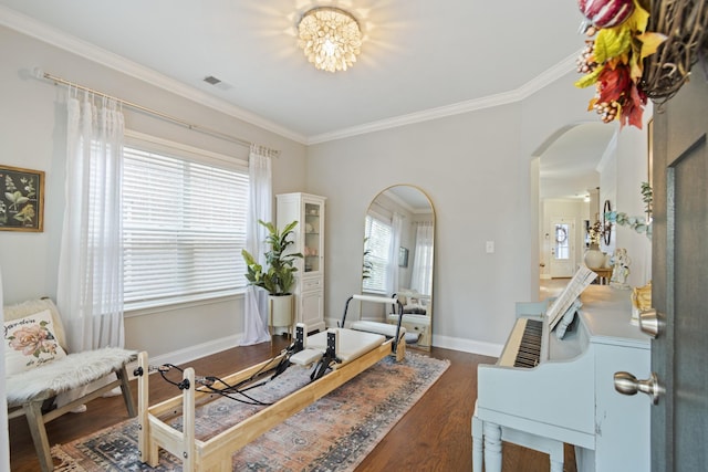 living area featuring baseboards, visible vents, arched walkways, ornamental molding, and dark wood-style flooring