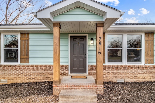 doorway to property with crawl space and brick siding