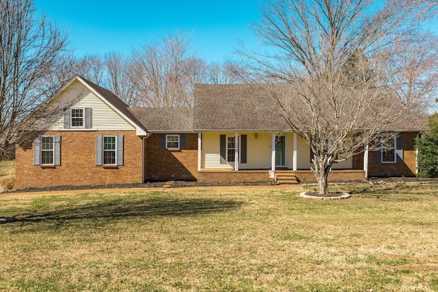 ranch-style house featuring a front lawn, roof with shingles, a porch, and brick siding