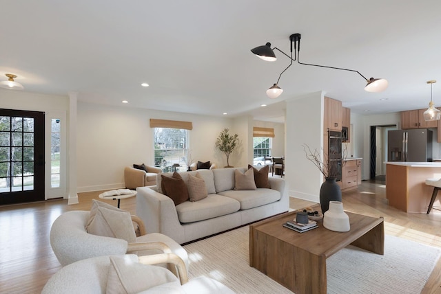 living room with baseboards, light wood finished floors, and recessed lighting