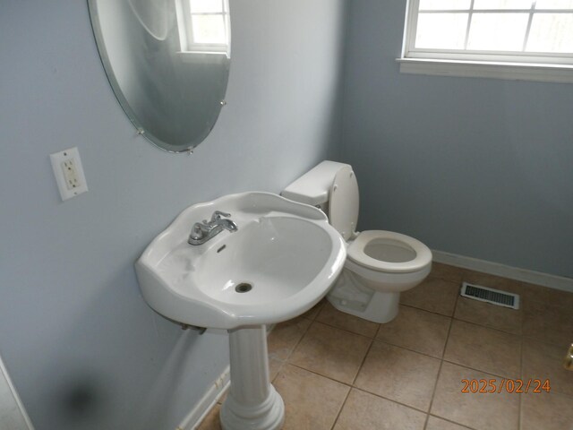 bathroom featuring toilet, plenty of natural light, visible vents, and tile patterned floors