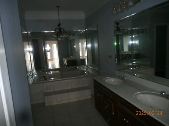 bathroom with double vanity, a garden tub, a sink, and tile patterned floors