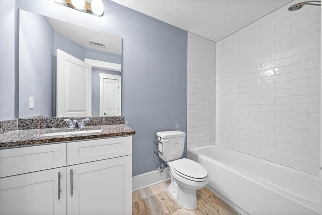 full bathroom featuring visible vents, toilet, vanity, wood finished floors, and shower / bathtub combination