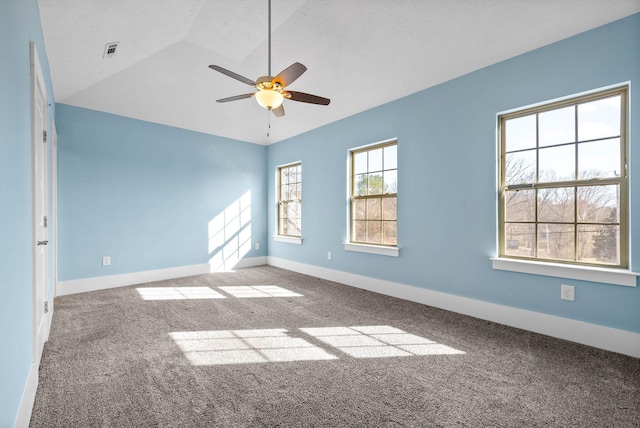 spare room with lofted ceiling, ceiling fan, light carpet, visible vents, and baseboards