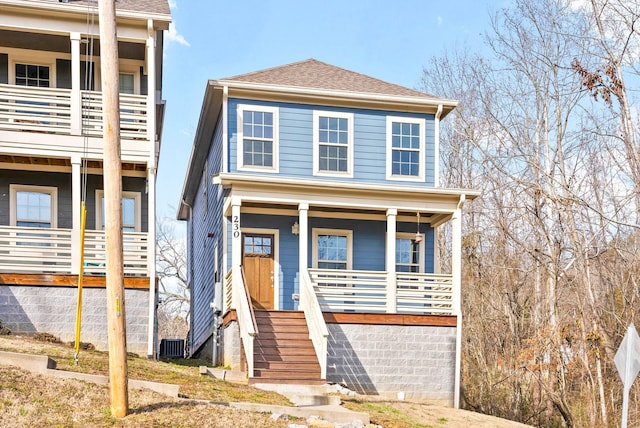 view of front of house with a porch, a shingled roof, and stairway