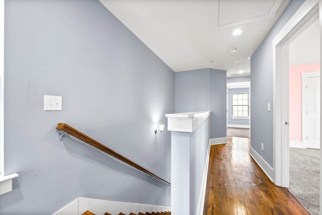 staircase with attic access, baseboards, and wood finished floors