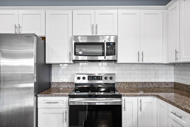 kitchen with appliances with stainless steel finishes, white cabinetry, and tasteful backsplash