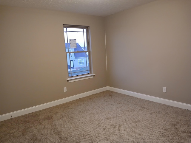 unfurnished room featuring a textured ceiling, baseboards, and carpet flooring