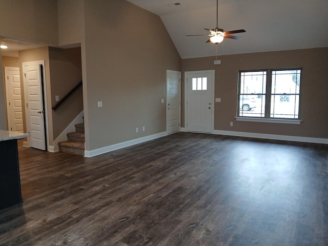 entryway with dark wood-style floors, stairs, baseboards, and high vaulted ceiling