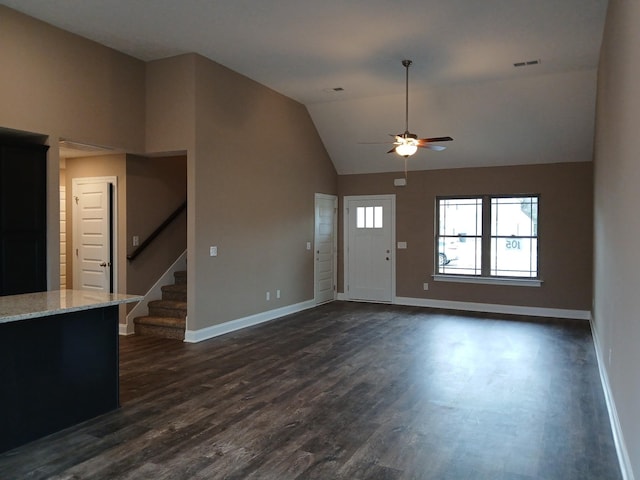 entryway with vaulted ceiling, dark wood-type flooring, stairway, and baseboards