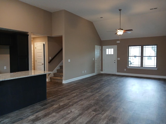 entryway with dark wood-style floors, lofted ceiling, visible vents, and stairs