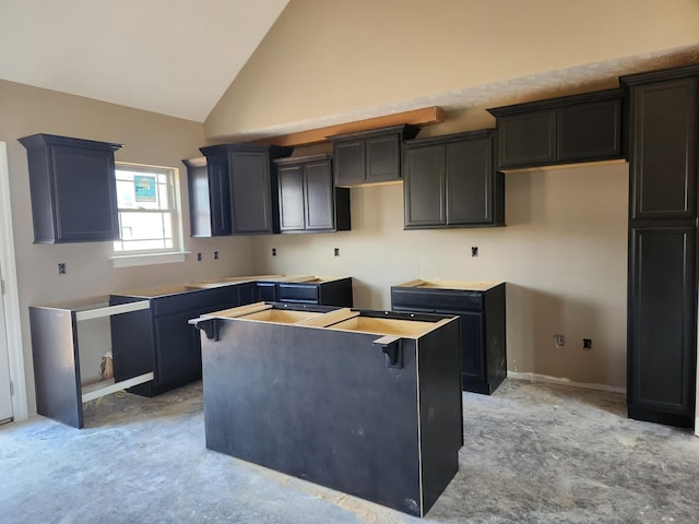 kitchen featuring high vaulted ceiling, a kitchen island, and baseboards