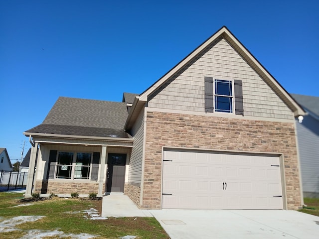 view of front facade featuring driveway, a garage, stone siding, roof with shingles, and a porch