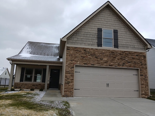 traditional-style house with an attached garage, driveway, and stone siding