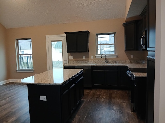 kitchen featuring light stone counters, dark wood-type flooring, a sink, a kitchen island, and black appliances