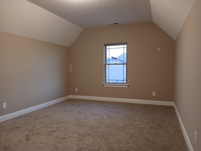 bonus room with lofted ceiling, carpet flooring, visible vents, and baseboards