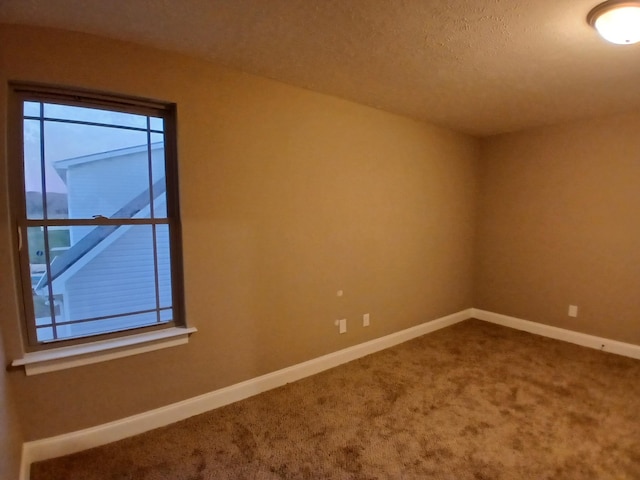 unfurnished room featuring carpet floors and baseboards