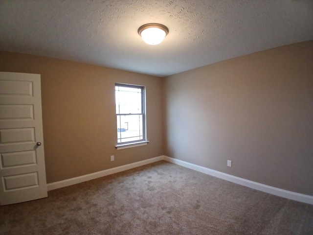 unfurnished room with a textured ceiling, baseboards, and carpet flooring