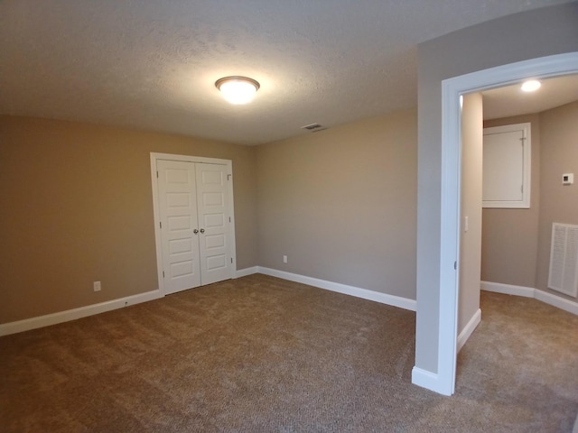 unfurnished bedroom with a closet, baseboards, visible vents, and carpet flooring