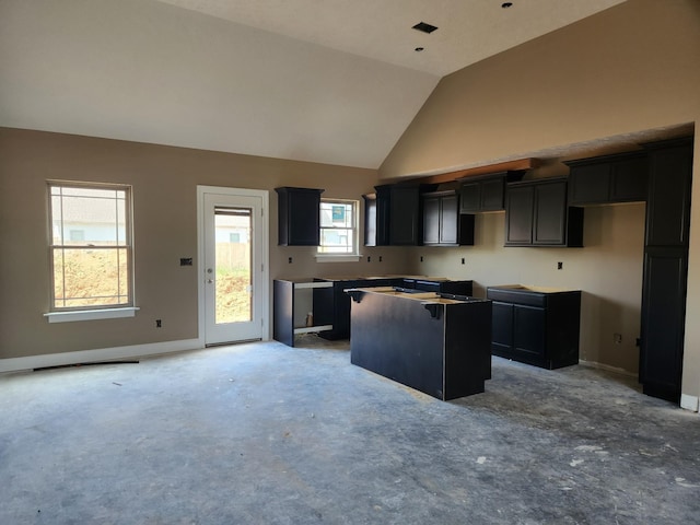 kitchen featuring high vaulted ceiling, a center island, and baseboards