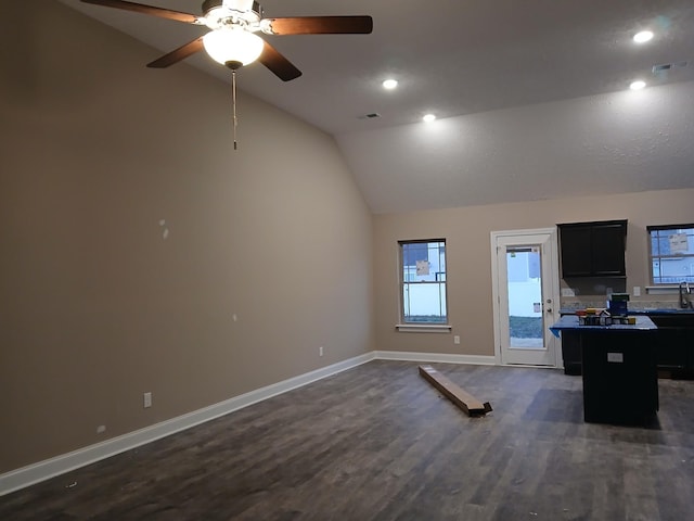 unfurnished office with dark wood-type flooring, a sink, visible vents, baseboards, and vaulted ceiling