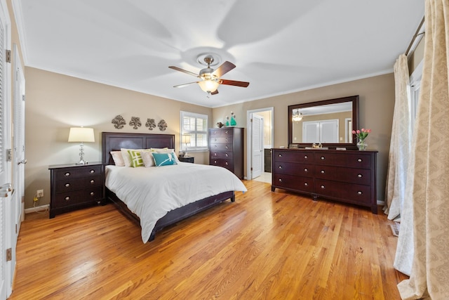 bedroom featuring ornamental molding, light wood-style flooring, baseboards, and a ceiling fan