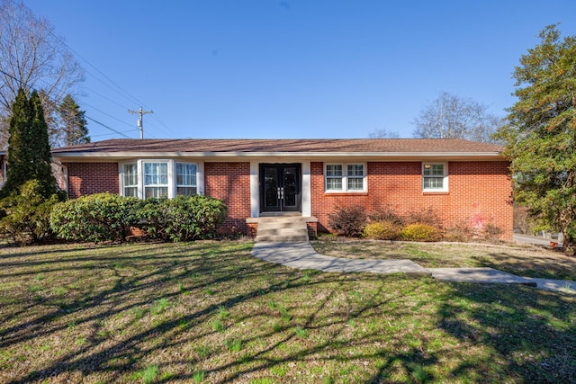 ranch-style house with a front yard, french doors, and brick siding