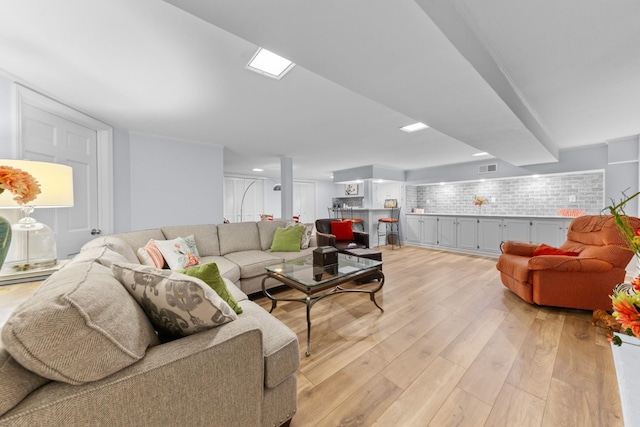 living room with light wood-style flooring and visible vents