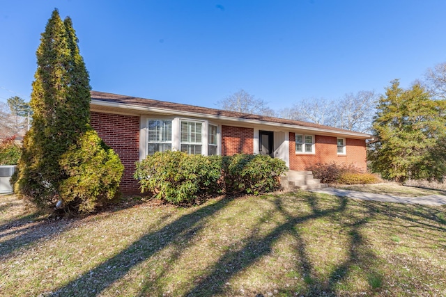 ranch-style house with a front lawn and brick siding