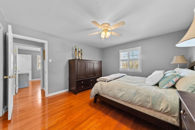 bedroom with ceiling fan, light wood finished floors, and baseboards