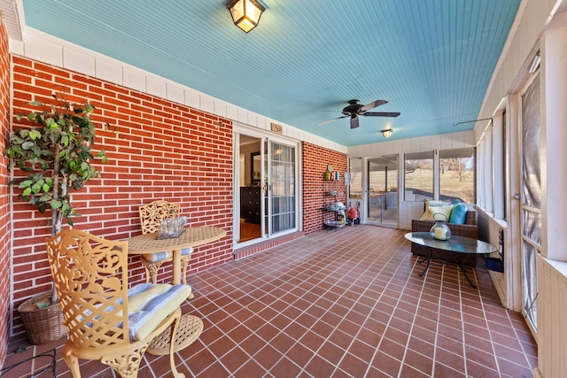 unfurnished sunroom featuring a ceiling fan