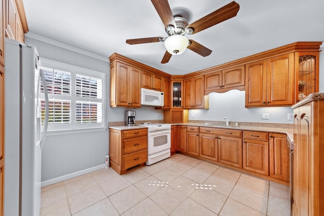 kitchen featuring white appliances, brown cabinetry, a sink, and glass insert cabinets