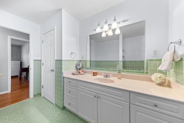 bathroom with wainscoting, tile walls, and vanity