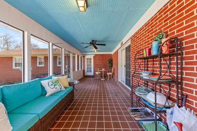 unfurnished sunroom featuring a ceiling fan