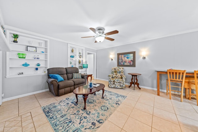 tiled living room featuring ceiling fan, built in shelves, baseboards, and crown molding