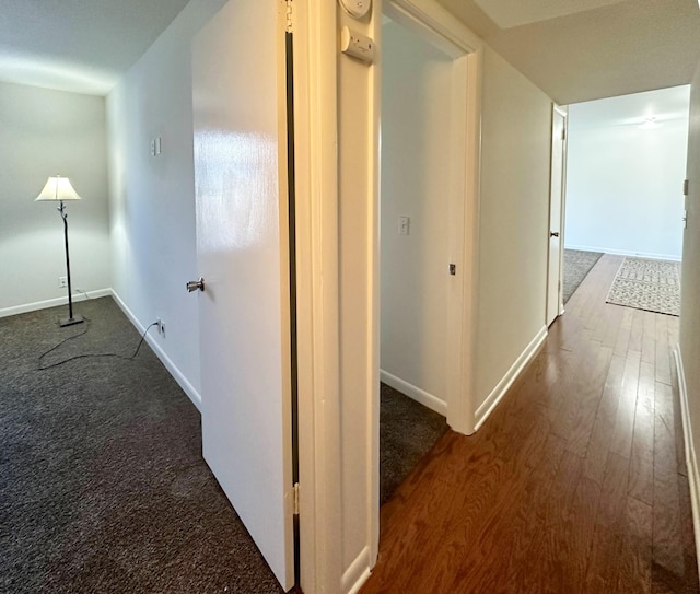 hall featuring baseboards and wood finished floors